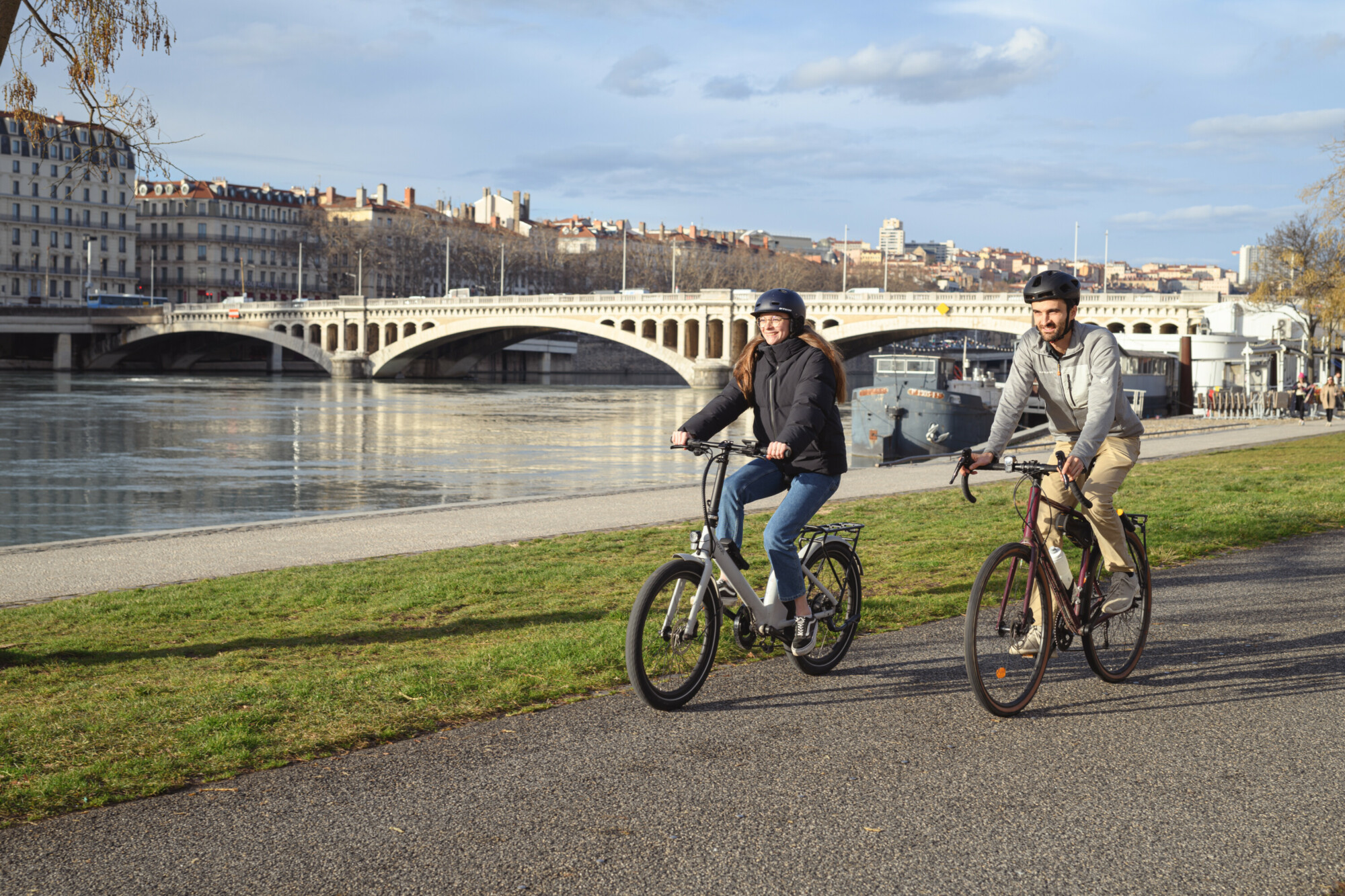 Deux personnes à vélo sur les quais du Rhône à Lyon