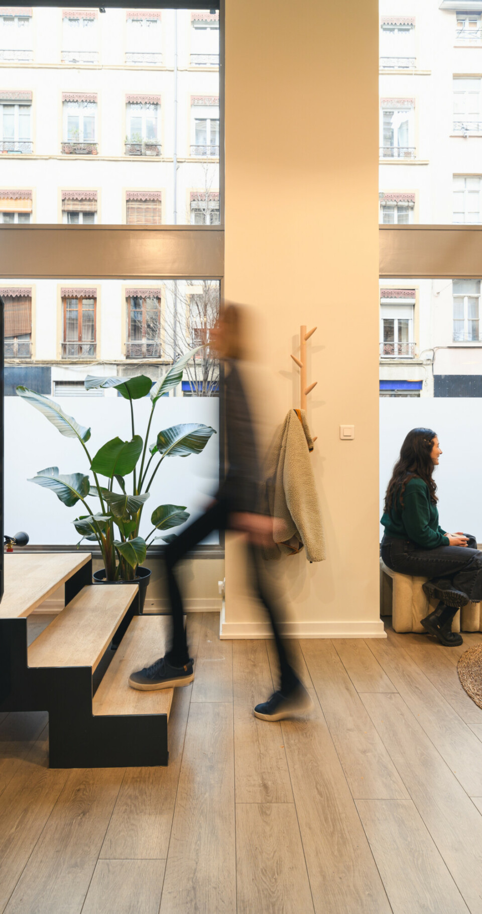 Personne qui monte les escalier tandis que deux personnes discutent